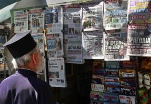 File picture of Greek Orthodox priest reading newspaper headlines at a kiosk in Athens