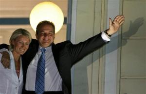 File picture of Greek Prime Minister Costas Karamanlis and his wife Natassa waving to supporters of his Conservative "New Democracy" party from a balcony of his headquarters in Athens